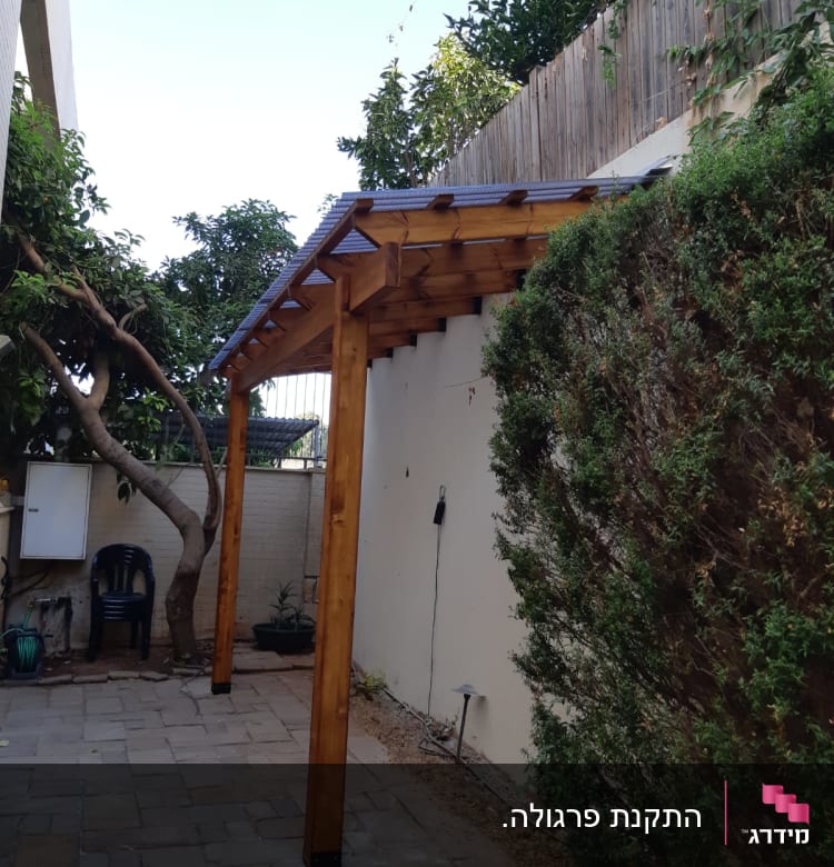 פרגולה מעץ בחצר עם שביל מרוצף